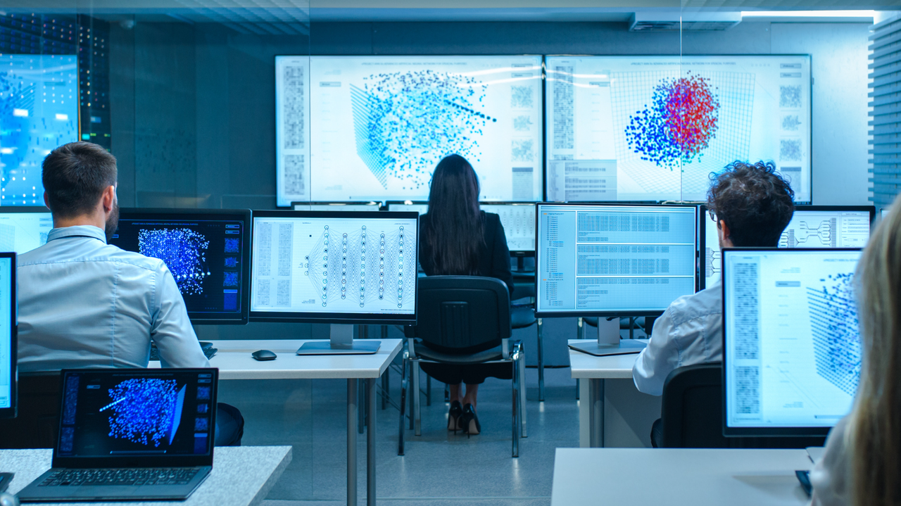 Team analyzing data on large screens